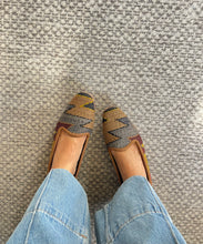 Load image into Gallery viewer, Pair of patterned loafers worn with light blue jeans on a textured gray floor.