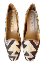 Load image into Gallery viewer, Pair of patterned slippers with &#39;Kilims&#39; branding on a white background
